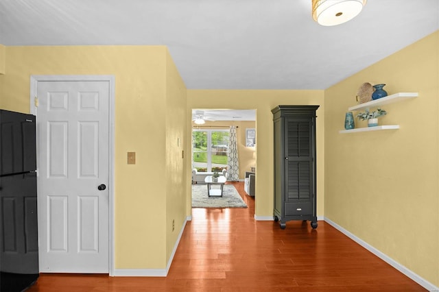 hall with wood finished floors and baseboards