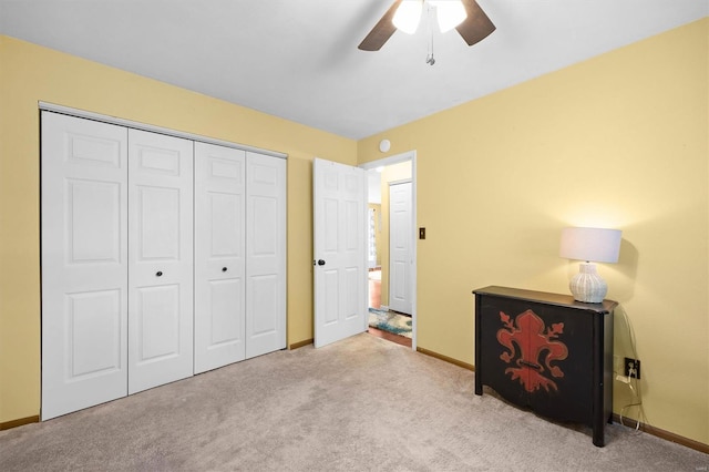 bedroom with baseboards, ceiling fan, a closet, and carpet flooring