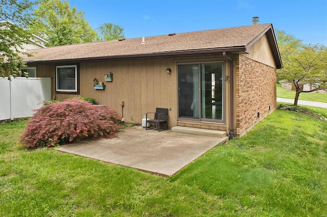 back of property featuring a patio, a shingled roof, fence, a yard, and brick siding