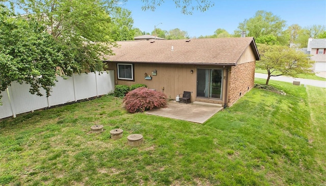 back of property with a patio, a lawn, and a shingled roof
