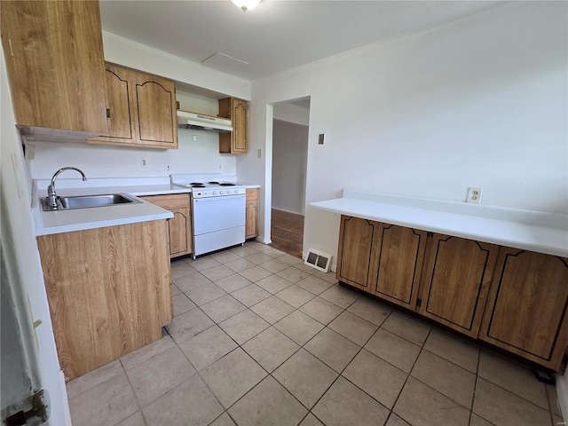 kitchen with visible vents, white range with electric cooktop, light countertops, under cabinet range hood, and a sink
