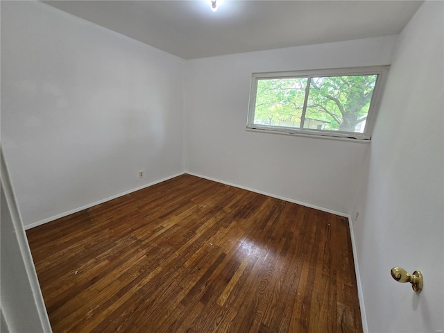 unfurnished room featuring baseboards and hardwood / wood-style flooring