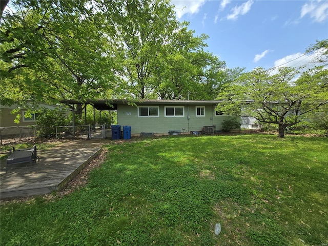 back of property with a lawn and fence