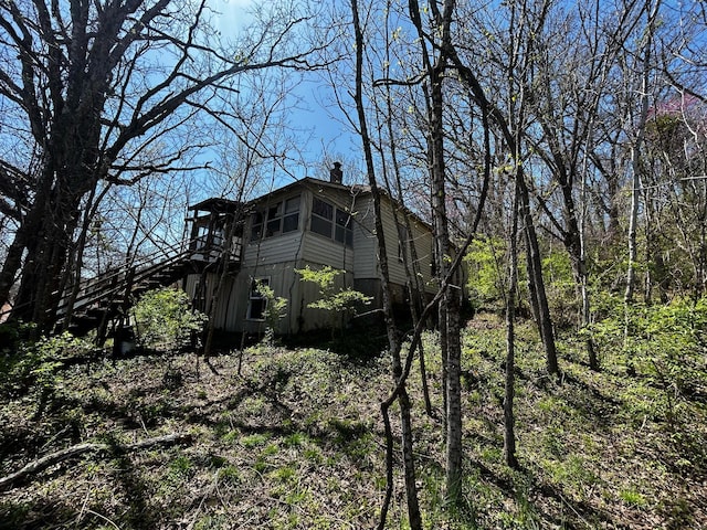 view of side of property featuring stairway and a wooden deck