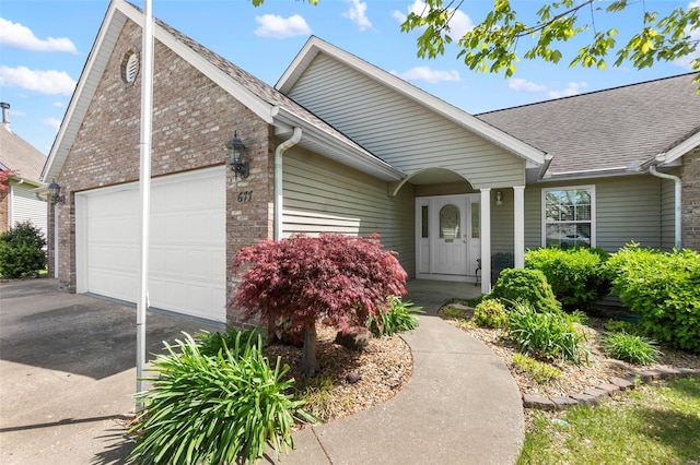 ranch-style house featuring driveway, a shingled roof, an attached garage, and brick siding