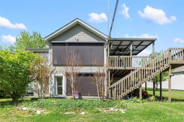 back of property with a lawn, stairway, and a wooden deck