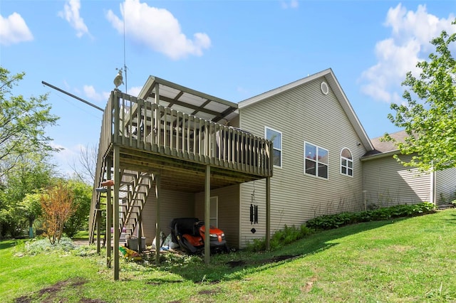 back of house featuring a lawn, a wooden deck, stairway, and a carport