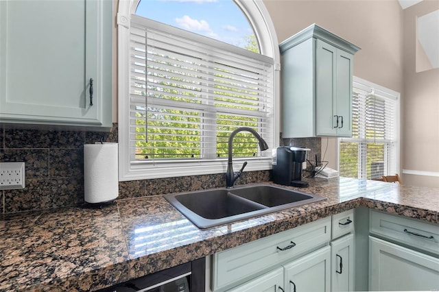 kitchen featuring a wealth of natural light, backsplash, and a sink