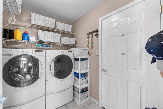 washroom with tile patterned floors, separate washer and dryer, laundry area, and baseboards