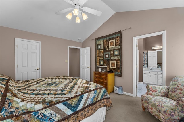 bedroom with lofted ceiling, a sink, light colored carpet, a ceiling fan, and ensuite bath