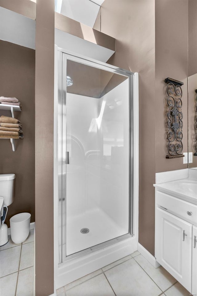 full bath featuring toilet, vanity, a shower stall, and tile patterned flooring
