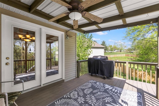 wooden terrace featuring area for grilling and a ceiling fan
