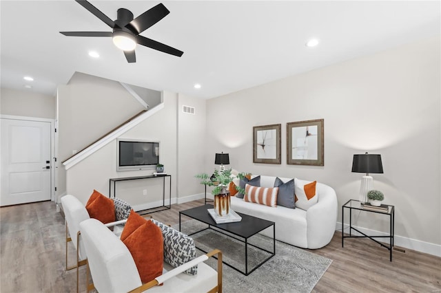 living area with visible vents, stairs, and wood finished floors