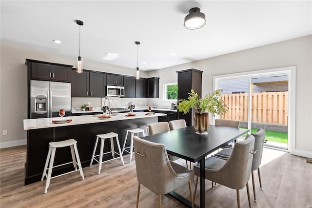 dining area with light wood-type flooring, recessed lighting, and baseboards