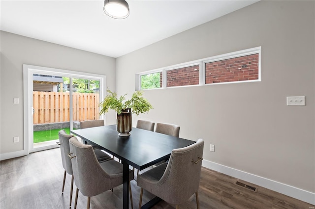 dining area with baseboards, wood finished floors, and visible vents