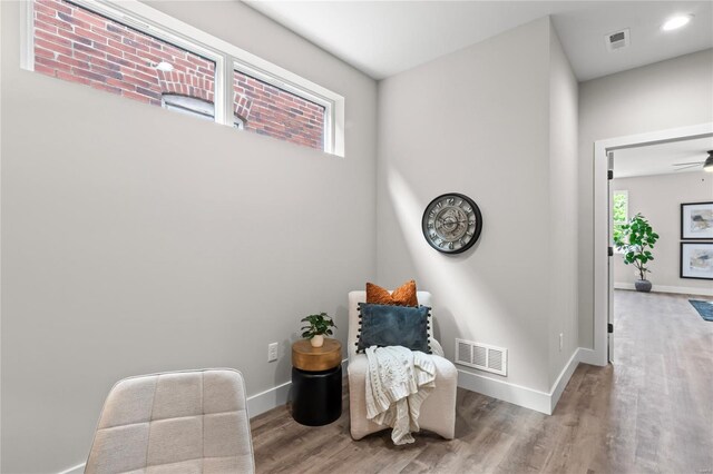 sitting room with visible vents, baseboards, and wood finished floors