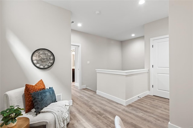 living area featuring recessed lighting, baseboards, an upstairs landing, wood finished floors, and visible vents