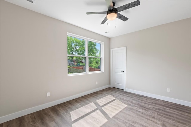 unfurnished room featuring baseboards, ceiling fan, and wood finished floors