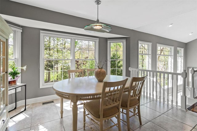 dining area with light tile patterned floors, baseboards, visible vents, and a wealth of natural light