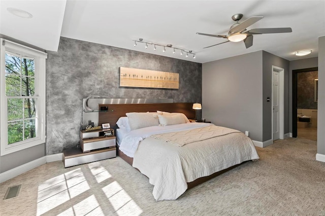 bedroom with visible vents, baseboards, ceiling fan, rail lighting, and carpet