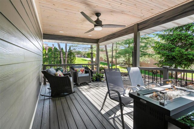 wooden terrace with ceiling fan and an outdoor fire pit