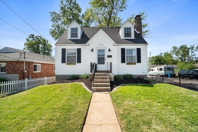 new england style home with a front lawn, fence, and a chimney