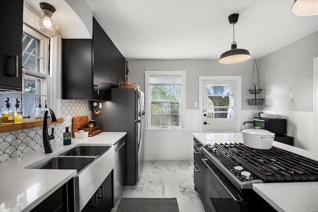 kitchen with dark cabinetry, light countertops, and appliances with stainless steel finishes