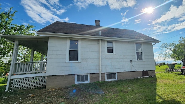 exterior space featuring a lawn and a shingled roof