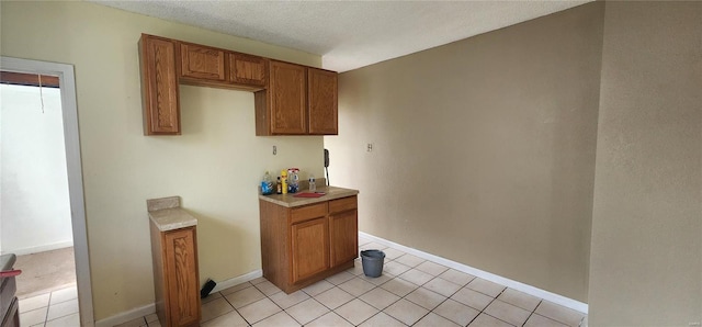 interior space featuring light tile patterned floors, light countertops, and brown cabinetry