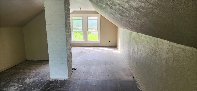 additional living space featuring decorative columns and vaulted ceiling