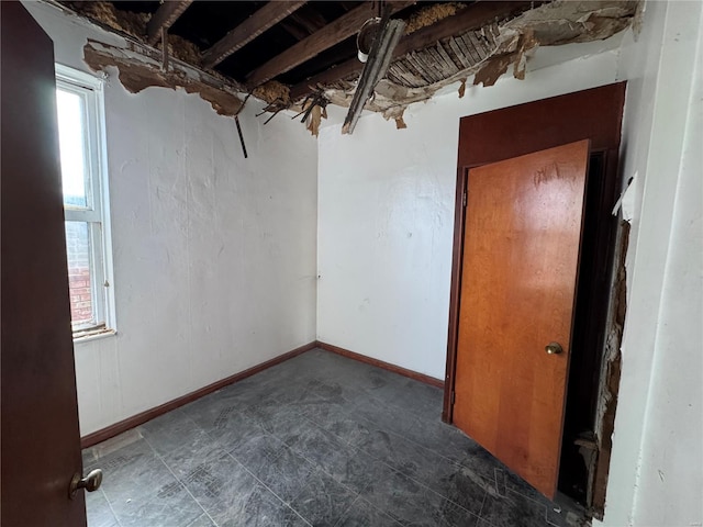 spare room featuring a healthy amount of sunlight and baseboards