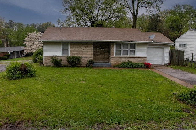 single story home featuring an attached garage, fence, a front yard, and aphalt driveway