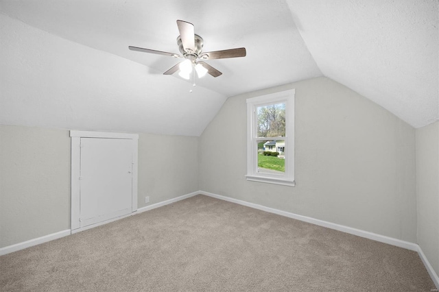 additional living space featuring a ceiling fan, baseboards, vaulted ceiling, and carpet floors