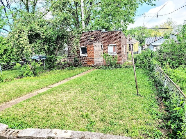 view of front of house featuring brick siding, a fenced backyard, and a front lawn