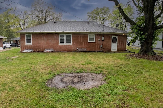 rear view of house with a yard and brick siding