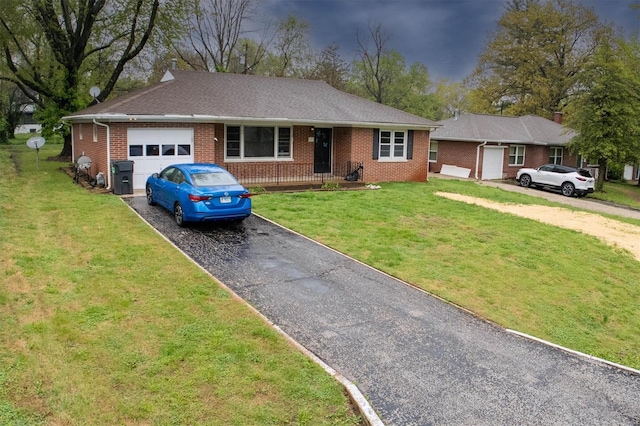 ranch-style home featuring brick siding, aphalt driveway, a front yard, and a garage