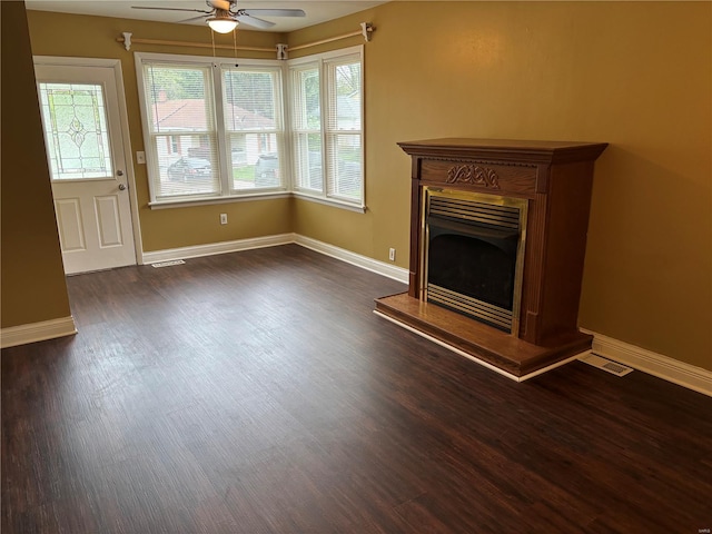 unfurnished living room featuring ceiling fan, dark wood-style floors, and a healthy amount of sunlight