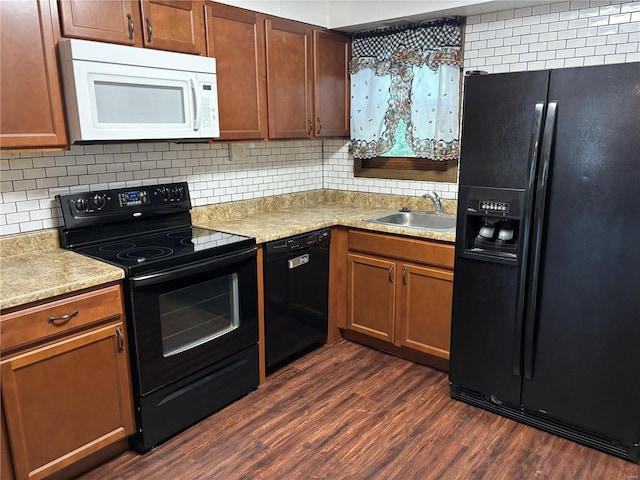 kitchen with a sink, light countertops, tasteful backsplash, and black appliances