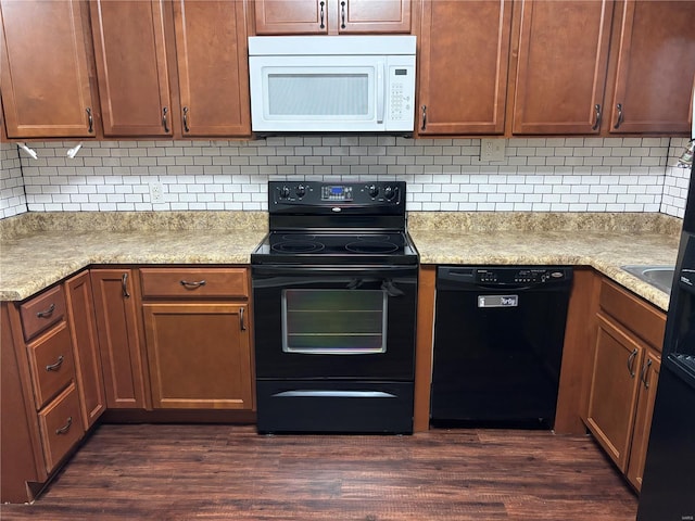 kitchen with tasteful backsplash, black appliances, and dark wood-type flooring