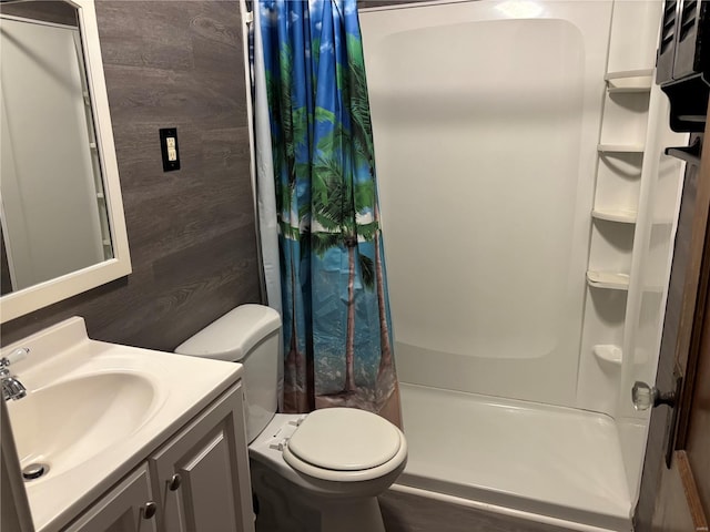 bathroom with vanity, wood walls, curtained shower, and toilet