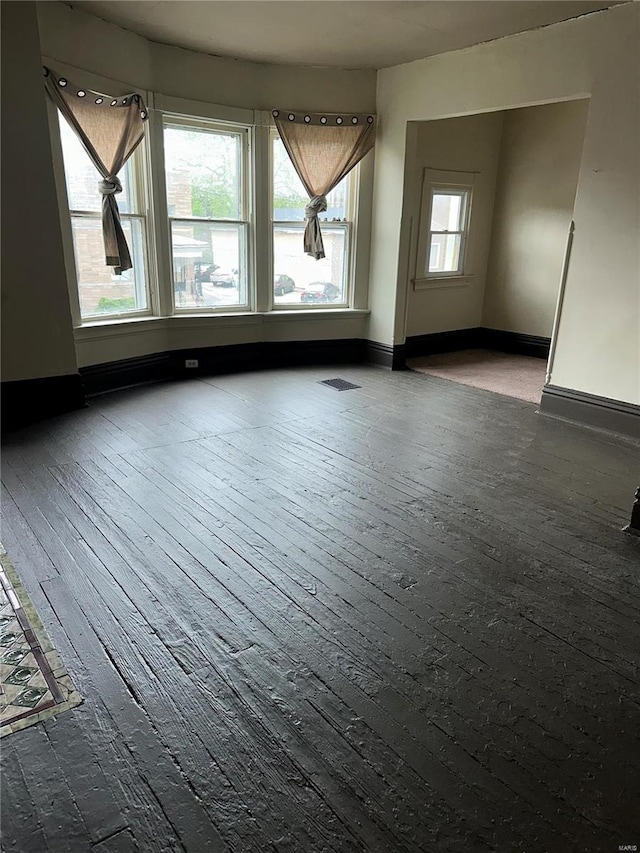 additional living space featuring baseboards, visible vents, and hardwood / wood-style floors
