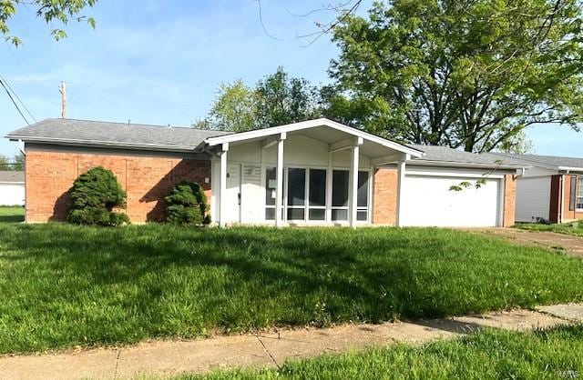 view of front facade featuring a garage, brick siding, and a front yard
