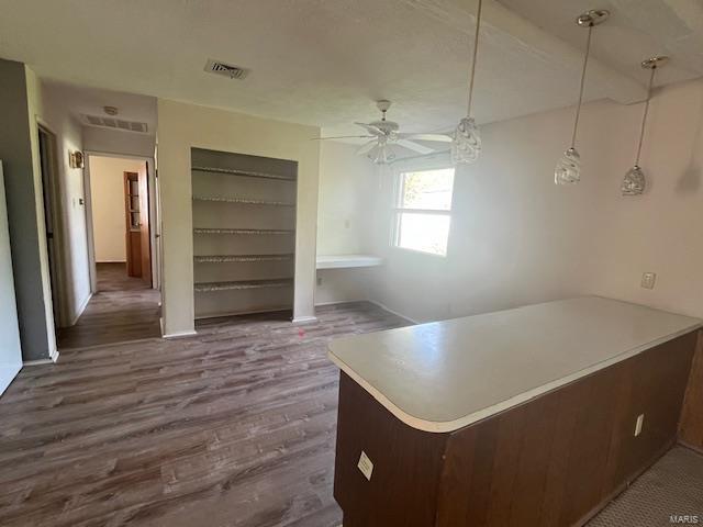 unfurnished dining area featuring visible vents, a ceiling fan, and dark wood-style floors