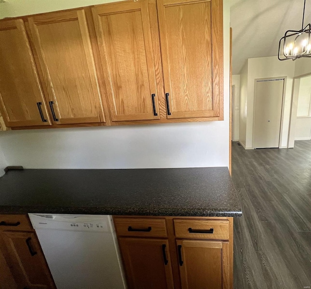 kitchen with brown cabinetry, decorative light fixtures, white dishwasher, dark wood finished floors, and dark stone countertops