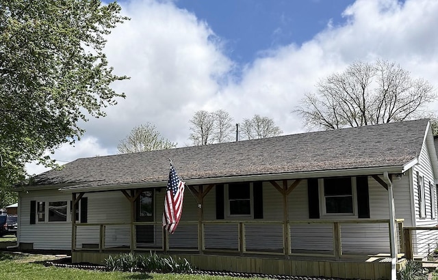 ranch-style home with a shingled roof and a porch