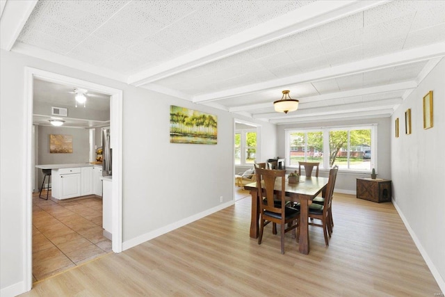 dining space featuring baseboards, visible vents, beam ceiling, and light wood-type flooring