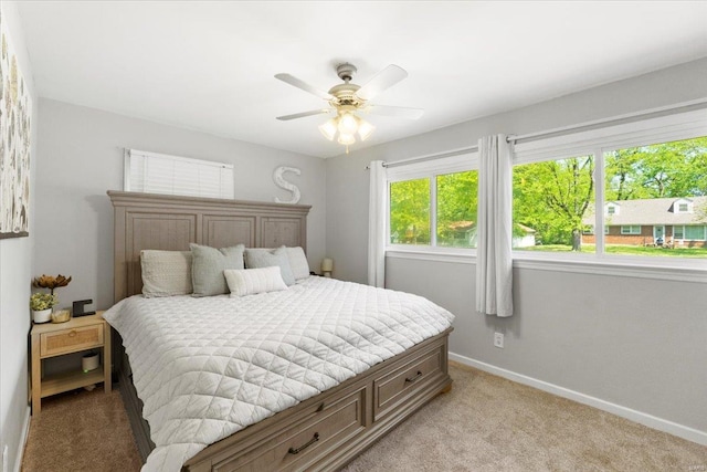 bedroom featuring baseboards, ceiling fan, and light carpet