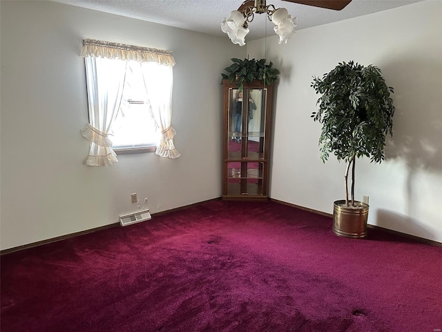 unfurnished room featuring carpet flooring, a textured ceiling, and visible vents