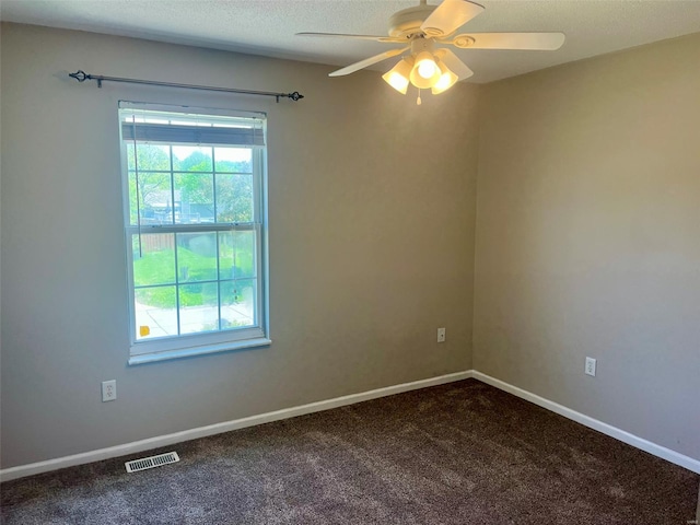 unfurnished room with visible vents, a ceiling fan, plenty of natural light, and dark colored carpet