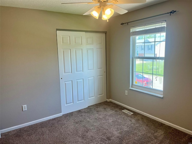 unfurnished bedroom with carpet floors, baseboards, visible vents, and ceiling fan